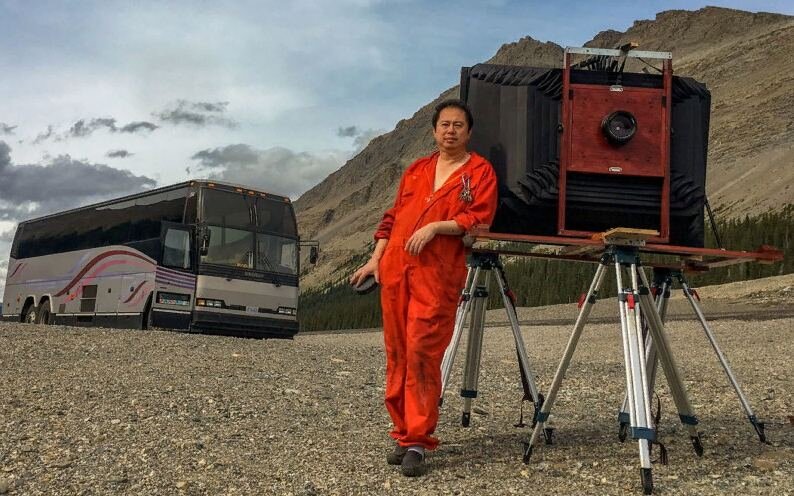 Билл Хао со своей камерой на фоне автобуса-фотолаборатории