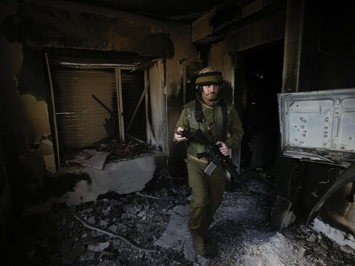    Израильский солдат осматривает дом, поврежденный боевиками Хамаса в кибуце Беэри в Израиле© AP Photo / Ariel Schalit