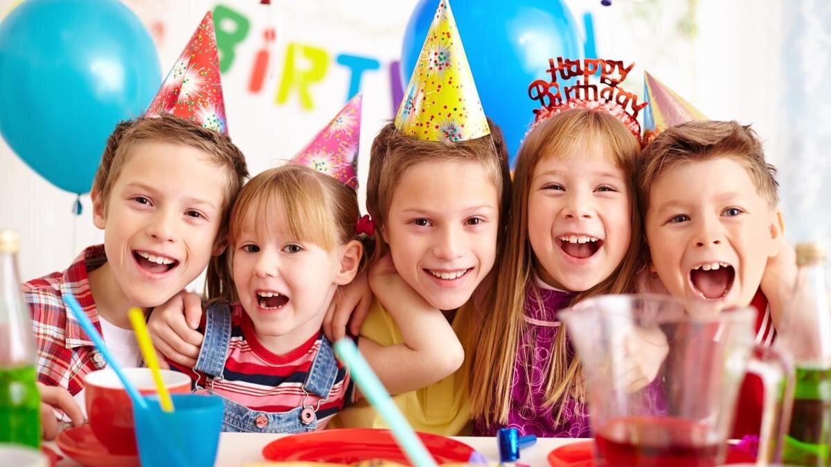   Дети празднуют день рождения сидя за праздничным столом:Freepik