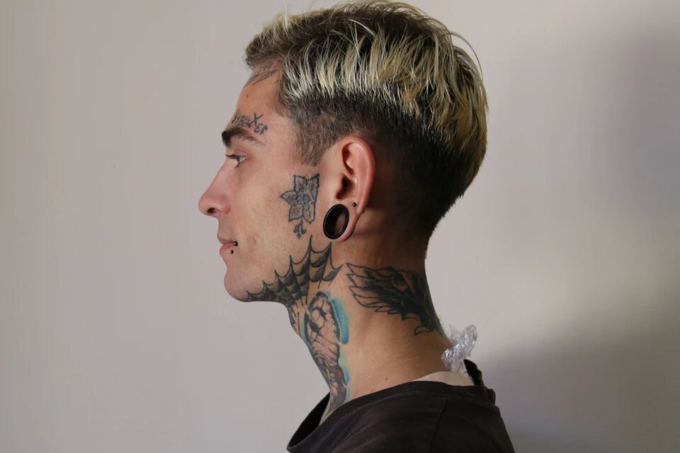 Многие приходят к косметологу, чтобы удалить рисунки на лице. Но этот парень выводить татуировки не собирается и вполне доволен своим телом 
Фото: Надежда ДАЦЮК