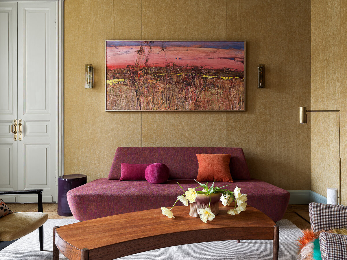 В гостиной сделанный на заказ диван и картина Сергя Карева. 