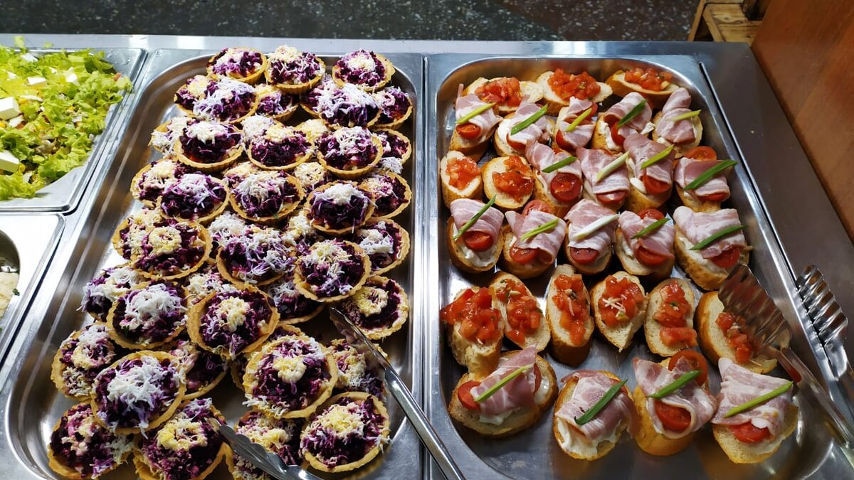 селедка под шубой в тарталетках слева, справа мини брускетты с беконом и черри