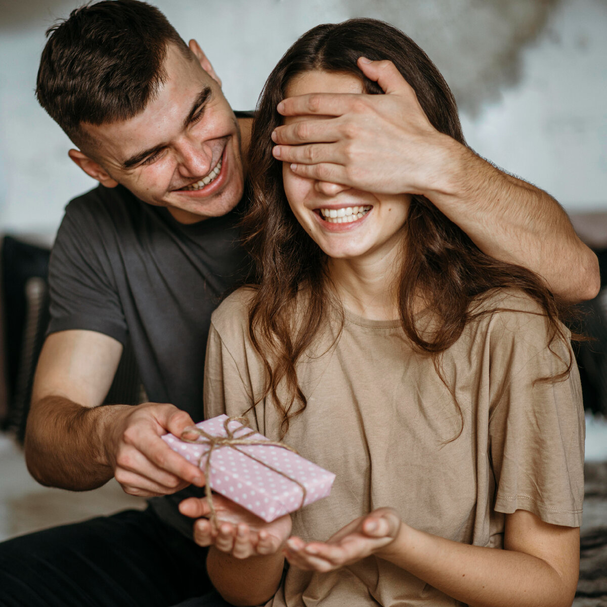 Изображение от <a href="https://ru.freepik.com/free-photo/young-man-surprising-girlfriend-with-present_10892392.htm?query=мужчина дарит женщине подарок">Freepik</a>