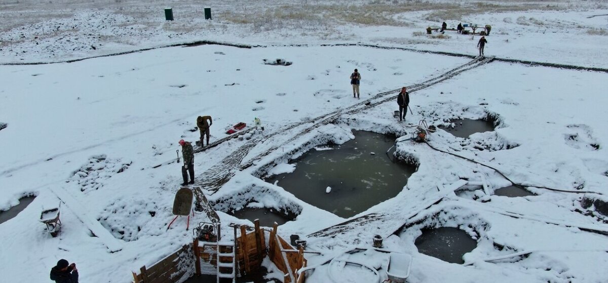 Частичный вид могильника Туннуг-1 в сибирской степи. Археологи работали до осени 2019 г., надеясь, что замерзшие грунтовые воды облегчат раскопки. Вместо этого им пришлось откачивать холодную воду из-под толстого слоя льда, чтобы раскопать участок.