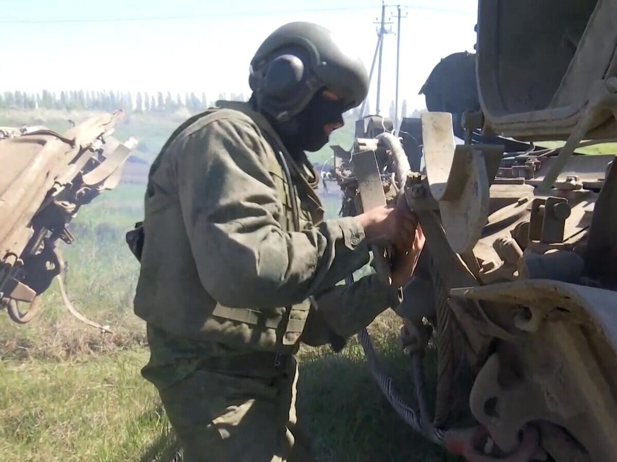    Сцепщик-такелажник бронированной ремонтно-эвакуационной машины (БРЭМ-1) проводит непрерывные работы по восстановлению и ремонту военной техники в полевых условиях© РИА Новости / Пресс-служба Минобороны РФ