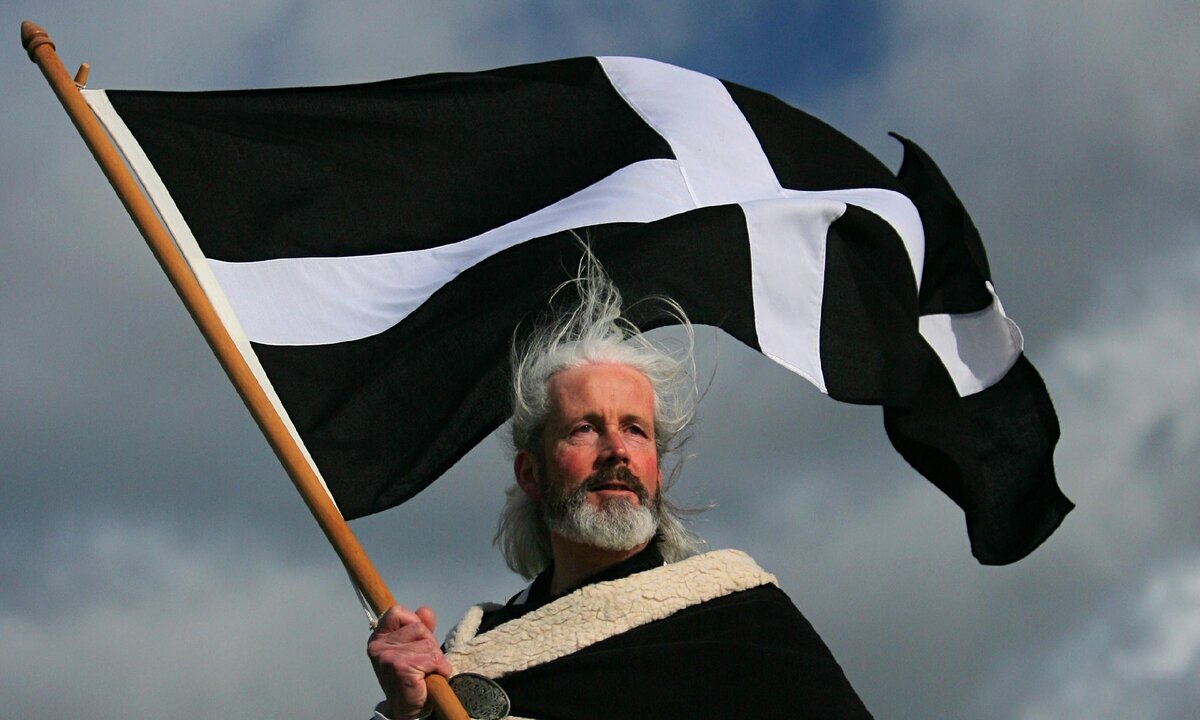 Житель Корнуолла в черно-белой накидке и с флагом малой родины. Из https://clck.ru/35wuAH 