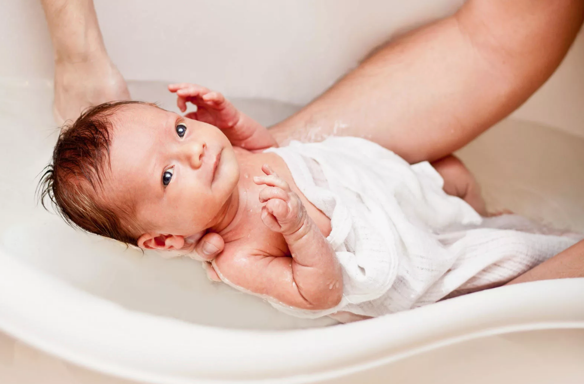 новорожденные в подгузниках. мама меняет подгузник ребенку. гигиена новорожденной девочки. ухаживание за грудным ребенком. уход за младенцем девочкой.