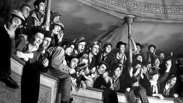 Галёрка. Эти люди также являются главными героями фильма. Мы будто наблюдаем за сценой их глазами, но почти их глазами. На самом же деле, камера установлена в партере.