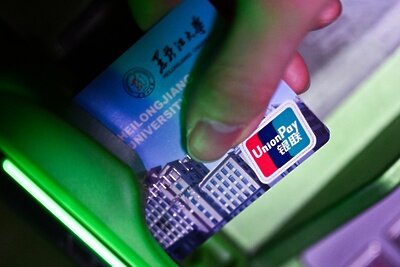    Девушка вставляет в банкомат карту международной платежной системы UnionPay. ©Рамиль Ситдиков РИА Новости