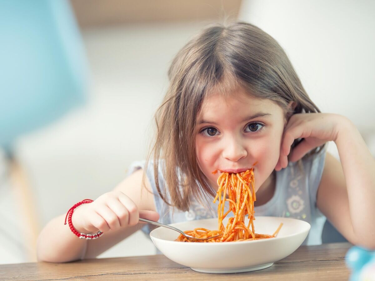    Девочка ест спагетти© iStock.com / MarianVejcik