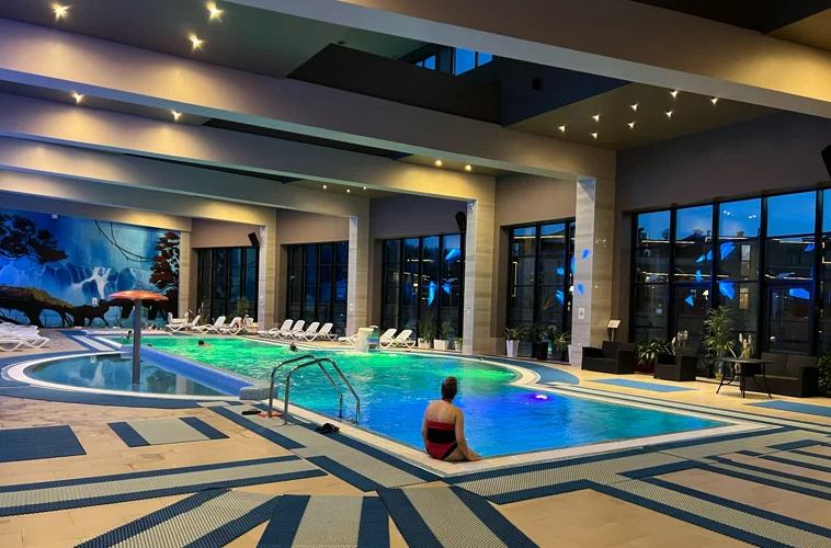 В отеле есть бассейн с панорамными окнами, через которые можно любоваться видом на парковую территорию загородного клуба