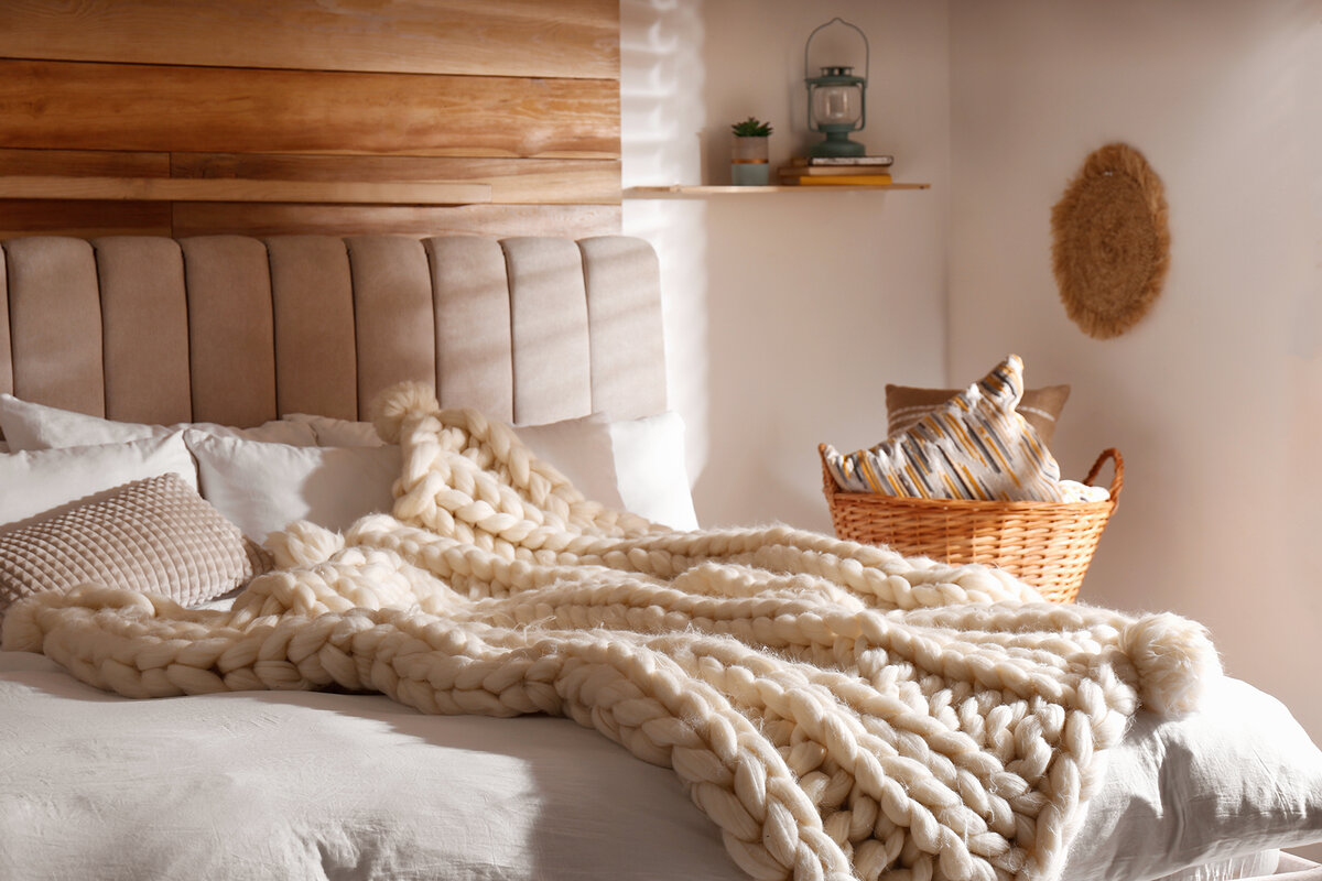 Фактурный плед крупной вязки - классический символ спальни в стиле хюгге.