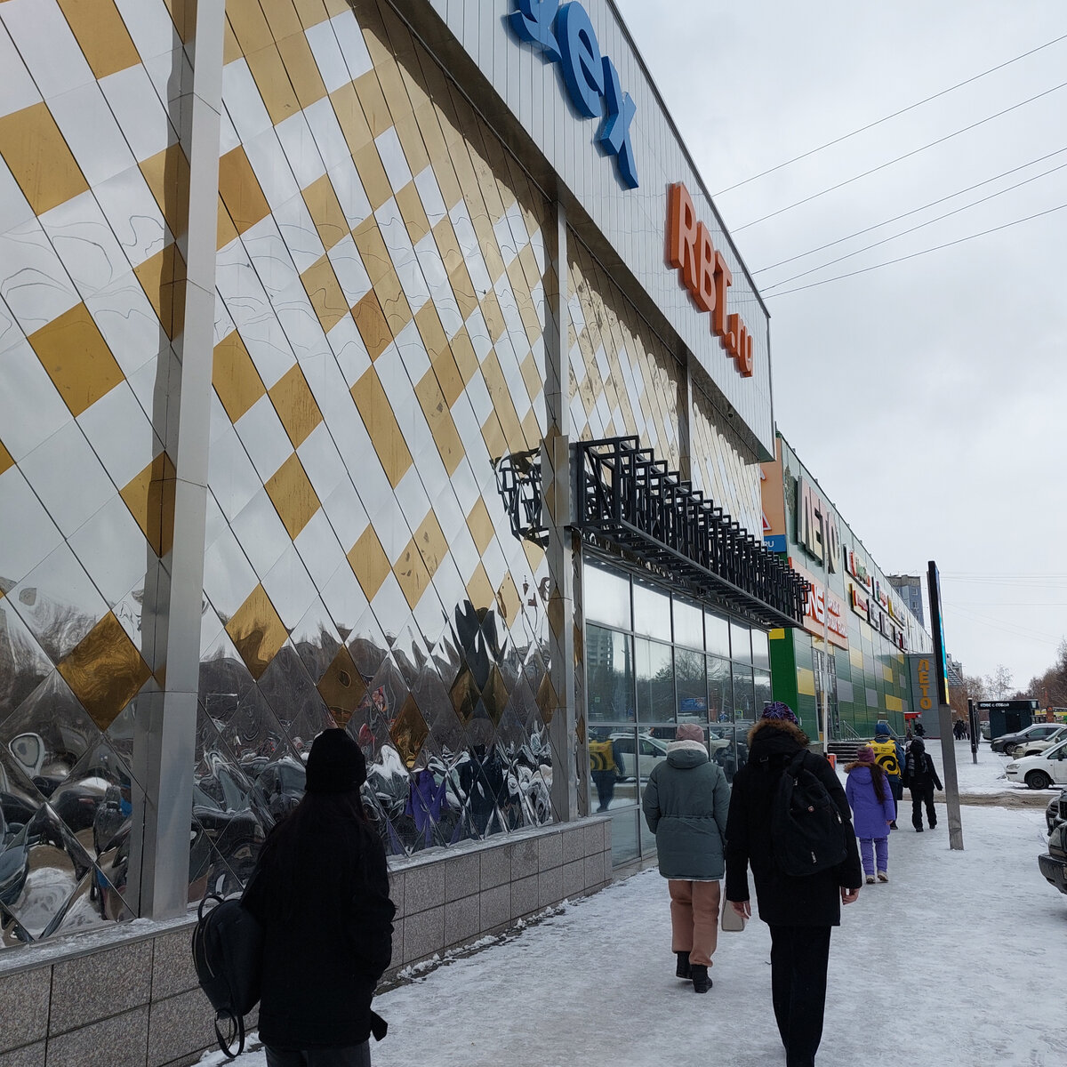 Впереди на зеленом фоне на здании ТЦ надпись - ЛЕТО, а нам так холодно! Мороза нет, но ветер...  Вчера шли и по нему довольно спокойно. потому что было всего около 0! 