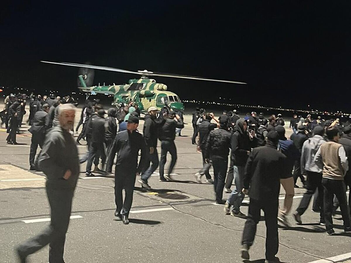    Люди на взлетно-посадочной полосе аэропорта Махачкалы© AP Photo