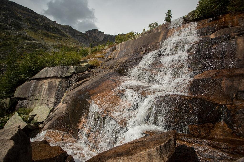 Мраморный водопад вытекает из Мраморного озера и падает вниз по плитам-мегалитам