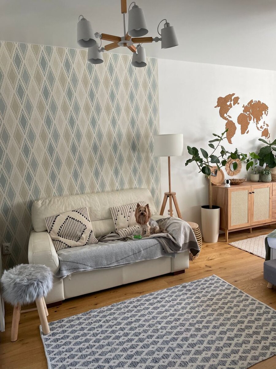 Сначала покажу, как оформлена зона отдыха в единственной комнате. Тут есть удобный диван на двух человек, настольная лампа, обеспечивающая приятный вечерний свет, и ковер, который отлично сочетается с пледом (по цвету) и обоями (по орнаменту)