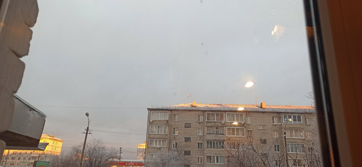 Вид из окна сегодня ранним утром. Солнце показалось из-за туч и позолотило крыши ярким жёлтым светом. Мало солнца сейчас и такие моменты особенно радуют.