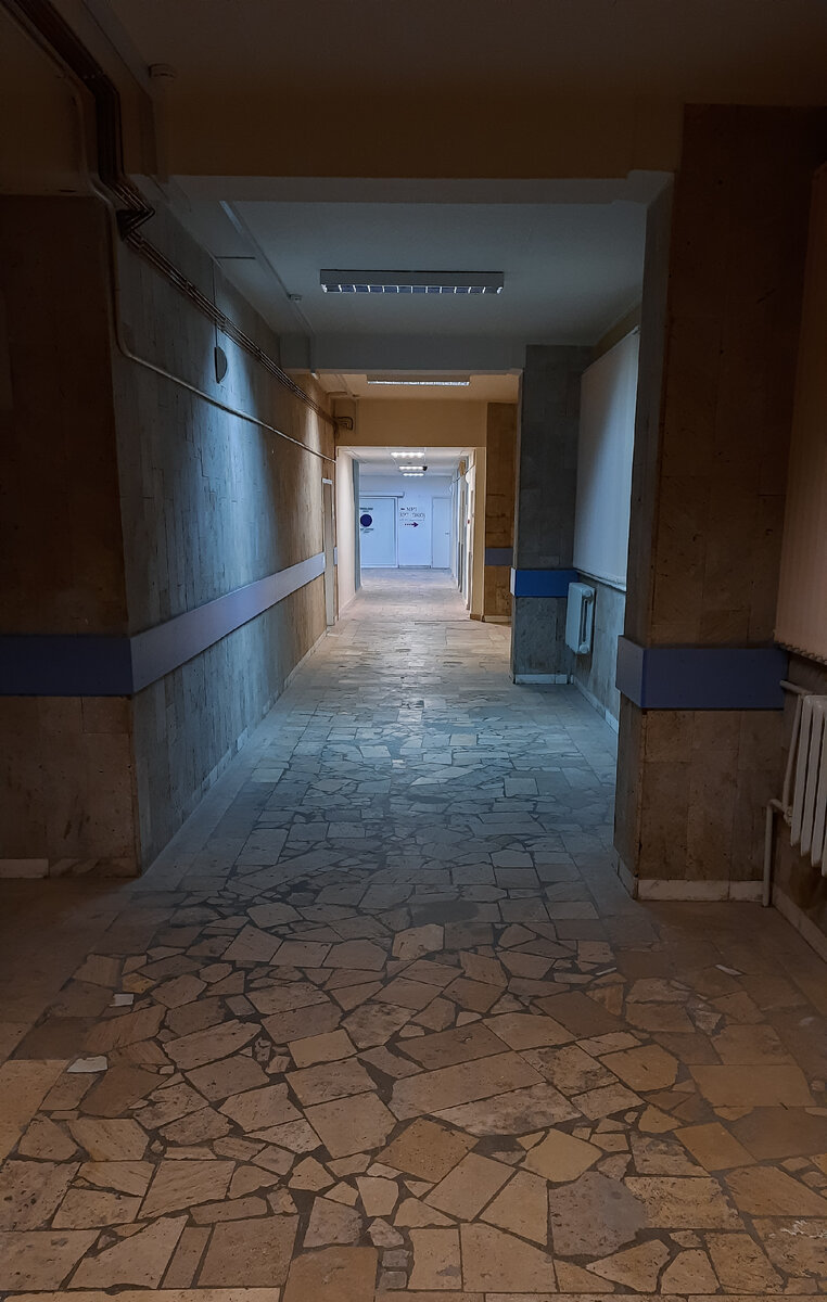 Служебные коридоры больницы, освещение тускнеет и лампы горят через одну, рабочее время закончено