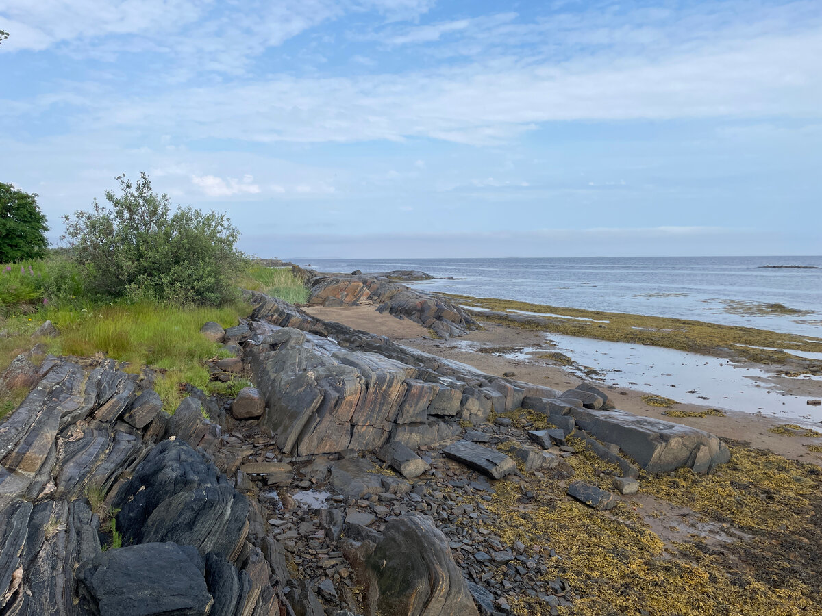 Живописный вид на нетронутую глухую часть острова, скалы на берегу и холодное море.