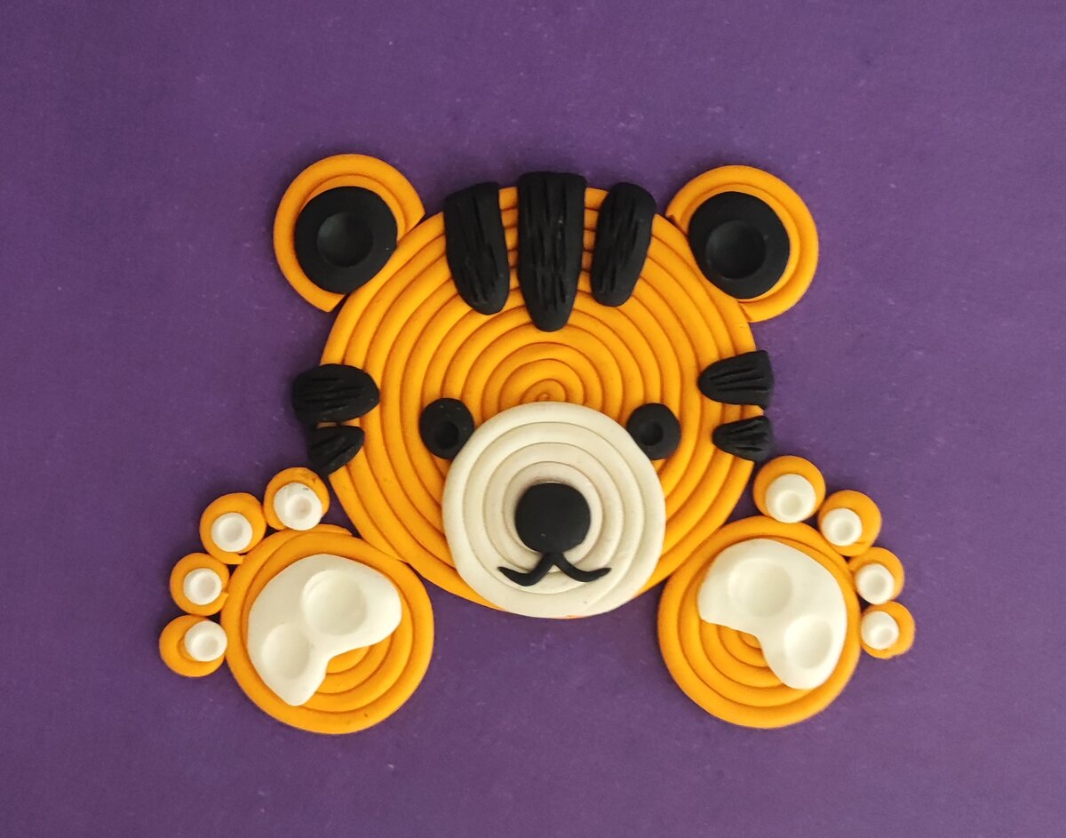 Готовый вариант аппликации из пластилина на цветном картоне Тигрёнок в спиральной технике.