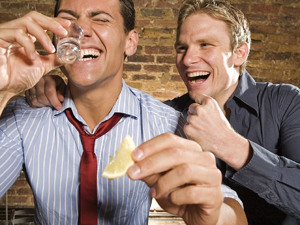 Алкогольные пары. Мужчины выпивают. Два парня смеются. Два друга пьют. Мужчина смеется.