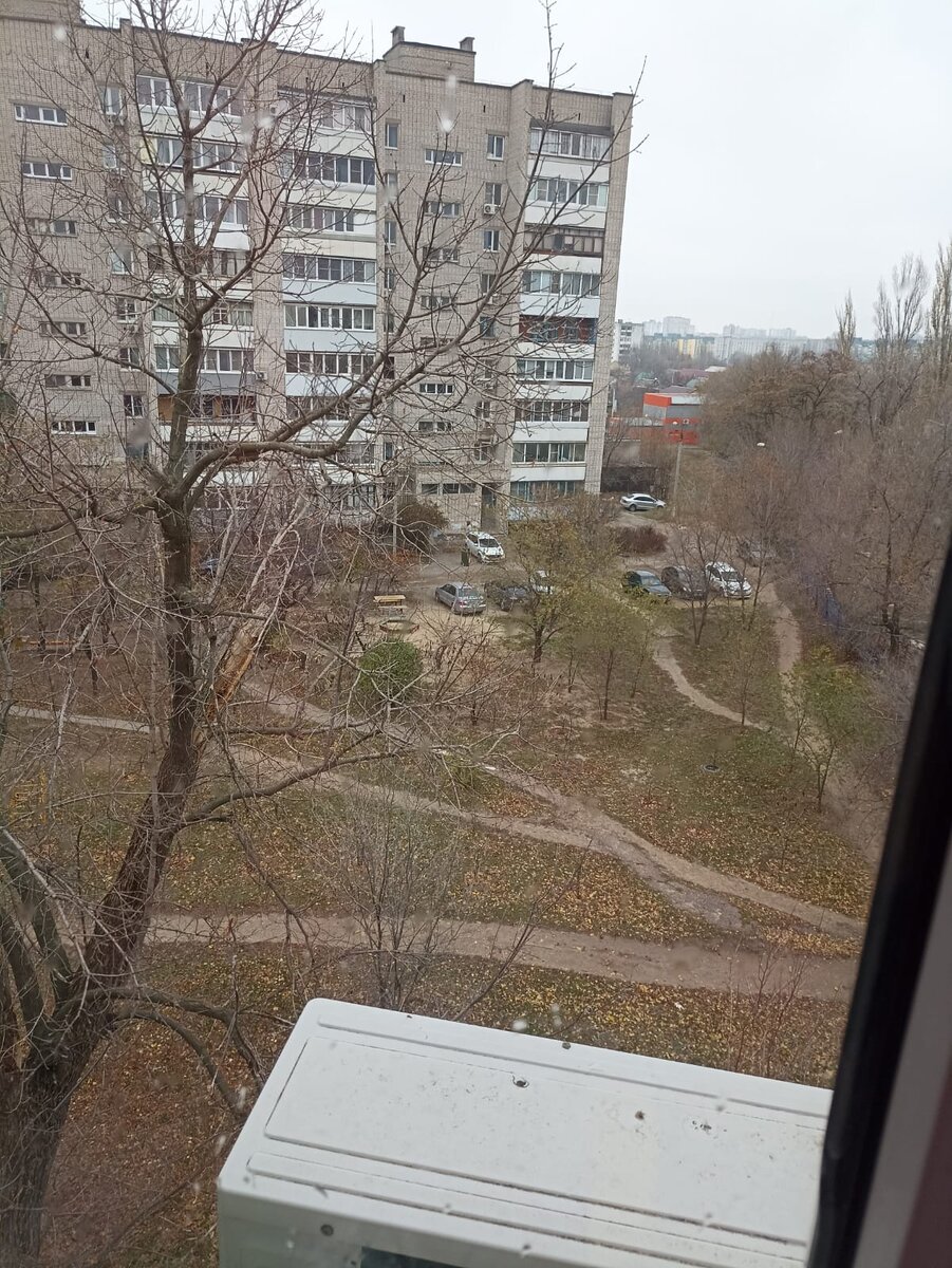 Вон там у белой машины, видите?