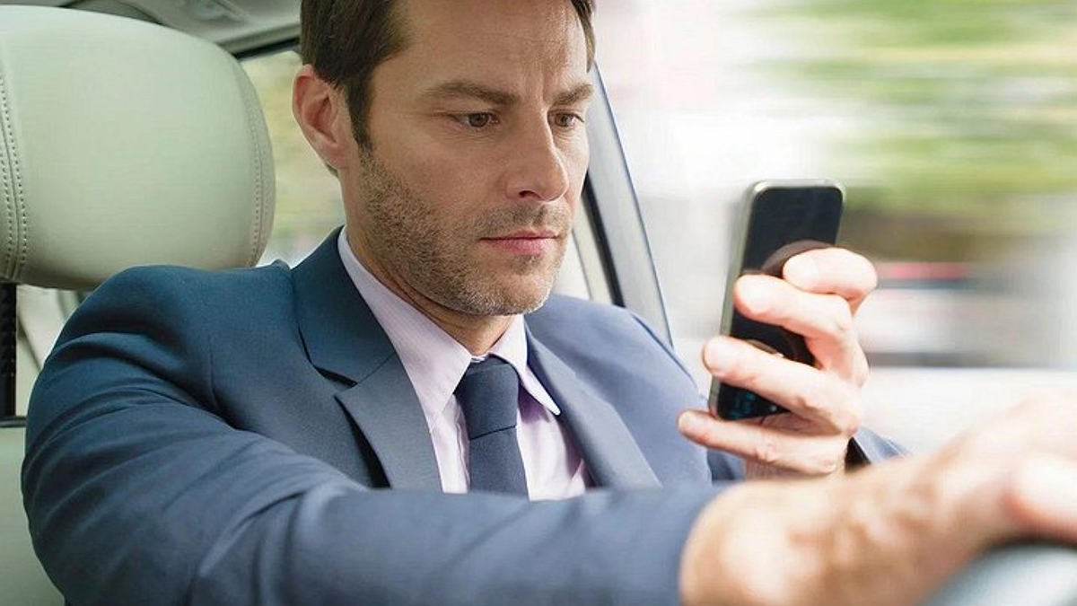 Водитель с телефоном в руках