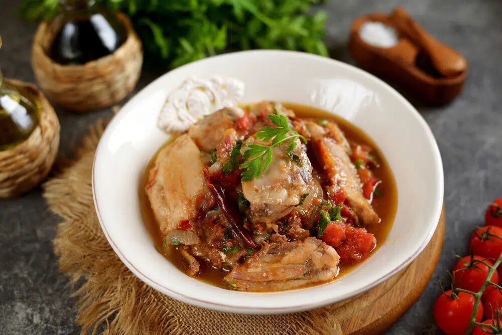 Ингредиенты: Курица (любые части) - 1 кг
Лук - 2 шт
Перец болгарский - 1 шт
Помидоры - 3 шт
Томатная паста - 3 ст л
Масло растительное - 50 гр
Чеснок - 2 зубчика
Сушёный базилик - По вкусу
Лавровый лист - По вкусу
Черный перец - По вкусу
Соль - По вкусу
Петрушка - По вкусу

Приготовление:
1.  Томатный соус. Лук почистить и нарезать соломкой. Затем обжарить его до золотистого цвета на растительном масле.
2.  Болгарский перец почистить от семечек и нарезать его четвертинками. Затем также слегка обжарить его вместе с луком.
3. Помидоры нарезать небольшими кусочками. Когда перец станет мягким, добавляем их к овощам и тушим в течении 5-7 минут. Затем добавляем томатную пасту 3 ст л (можно использовать томатный сок, но в чуть большем количестве), измельчённый чеснок, черный перец, лавровый лист, сушёный базилик, зелень петрушки и соль. Томим на медленном огне 10 минут, обязательно помешивая.
4.  Кусочки курицы выкладываем в глубокую сковороду и заливаем томатным соусом. Если соус получился густым, нужно добавить немного воды. Тушить минут 30-40 при закрытой крышке до полной готовности мяса. В конце добавляем рубленную зелень.

Готовое блюдо выкладываем на порционные тарелки.

Приятного аппетита!