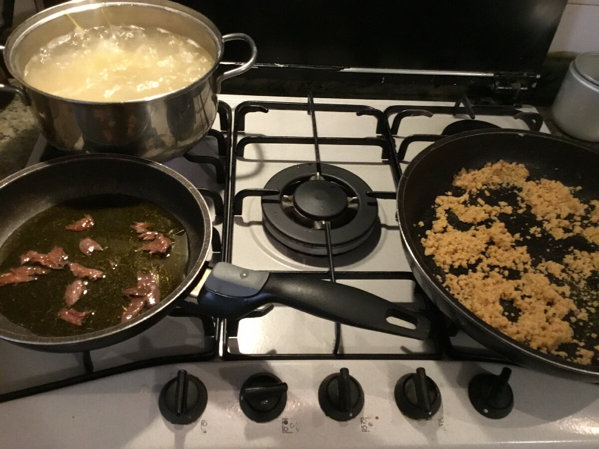 Начало банальное. Пока варятся макароны в одну сковороду насыпаем дробленый сухой хлеб (у меня панировочные сухари — так тоже можно:))) и слегка обжариваем в небольшом количестве оливкового масла, А во  второй сковороде готовим заправку для макарон, сначала я бросила филе анчоусов. 