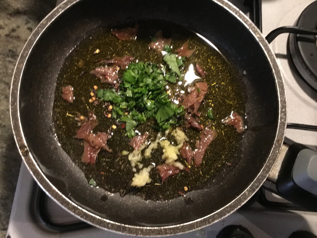 Потом к филе добавила немного дробленого красного жгучего перца, зубчик чеснока, и петрушку (половину от общего количества). Помешивая на среднем огне минут 7-8 можно получить довольно таки однородную заправку. 