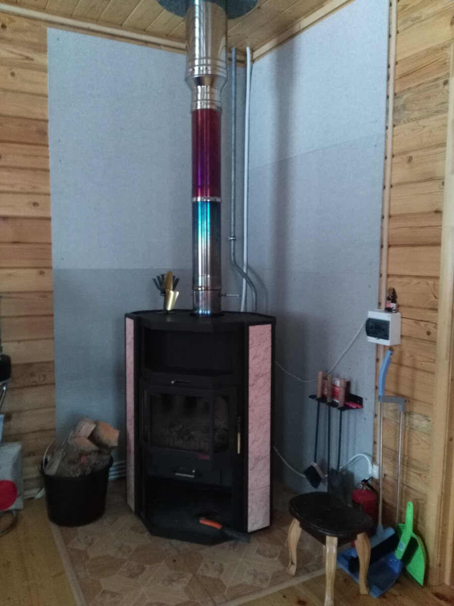 В углу гостиной располагается печь-камин с водяным контуром