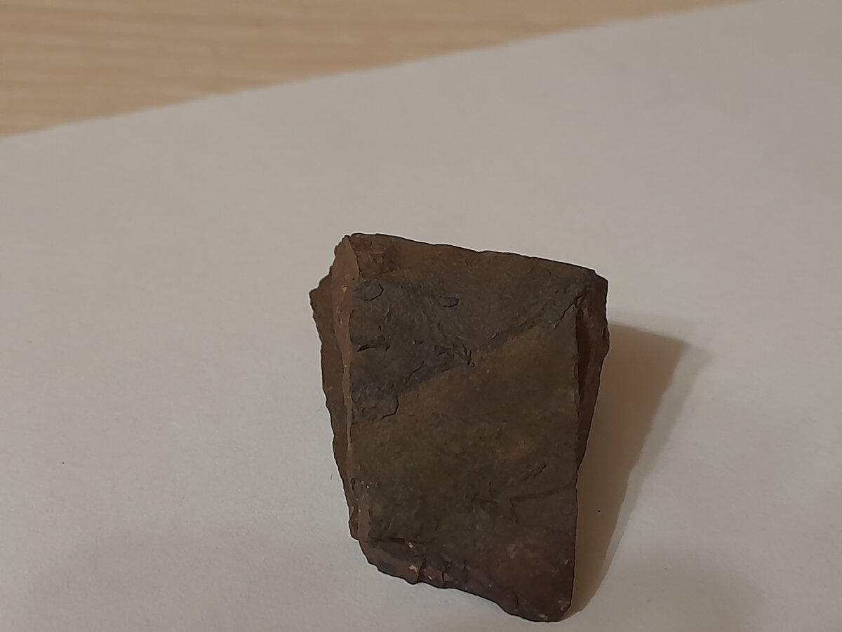 Верхняя часть метеорита (можно заметить небольшие прожилки железа).