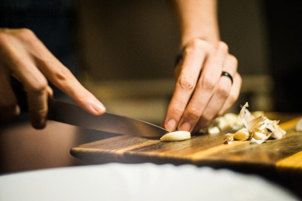 Женщина с разделочной доской. Smack the garlic by hand.