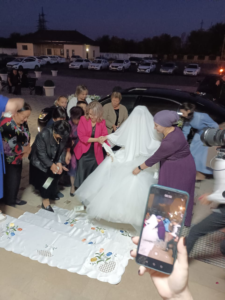 На ступеньках перед входом в ресторан невесту обсыпали сладостями  и денежными купюрами. 
