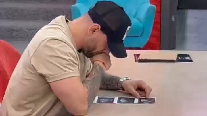 Максим Евстропов, по фото, пытается разглядеть пол малыша. Источник: соцсеть