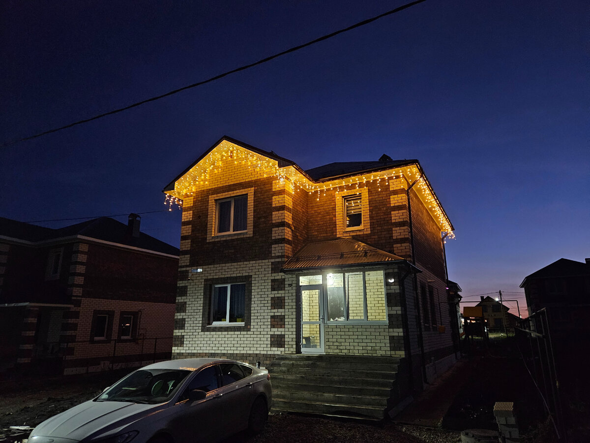 Гирлянду под карниз дома вешали монтажники водосточки