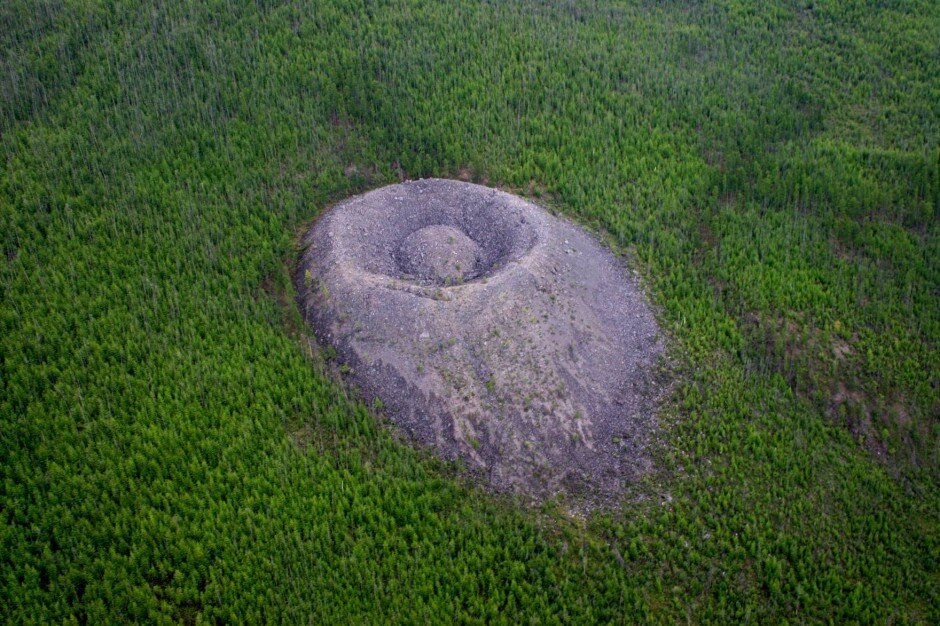 “Патомский кратер” на склоне сопки, покрытой лесом. Вид с юго-западной стороны. Снимок с вертолёта. 