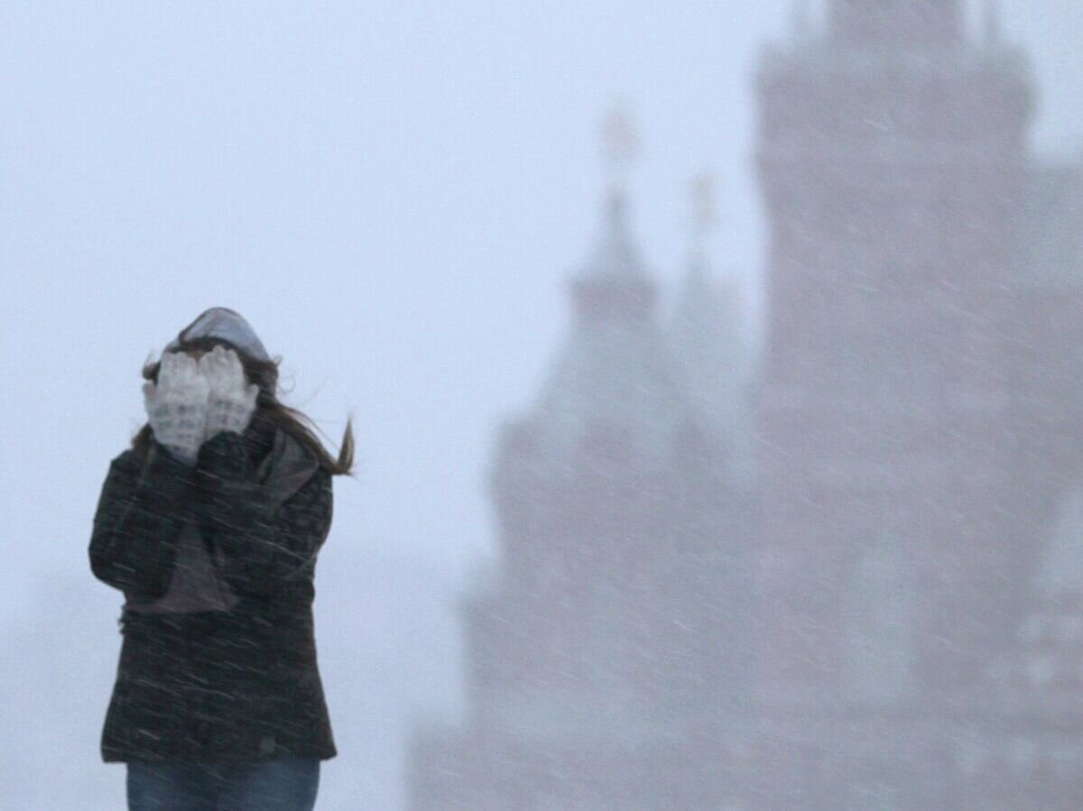    Девушка закрывает лицо от снега во время метели. Архивное фото© РИА Новости / Валерий Мельников