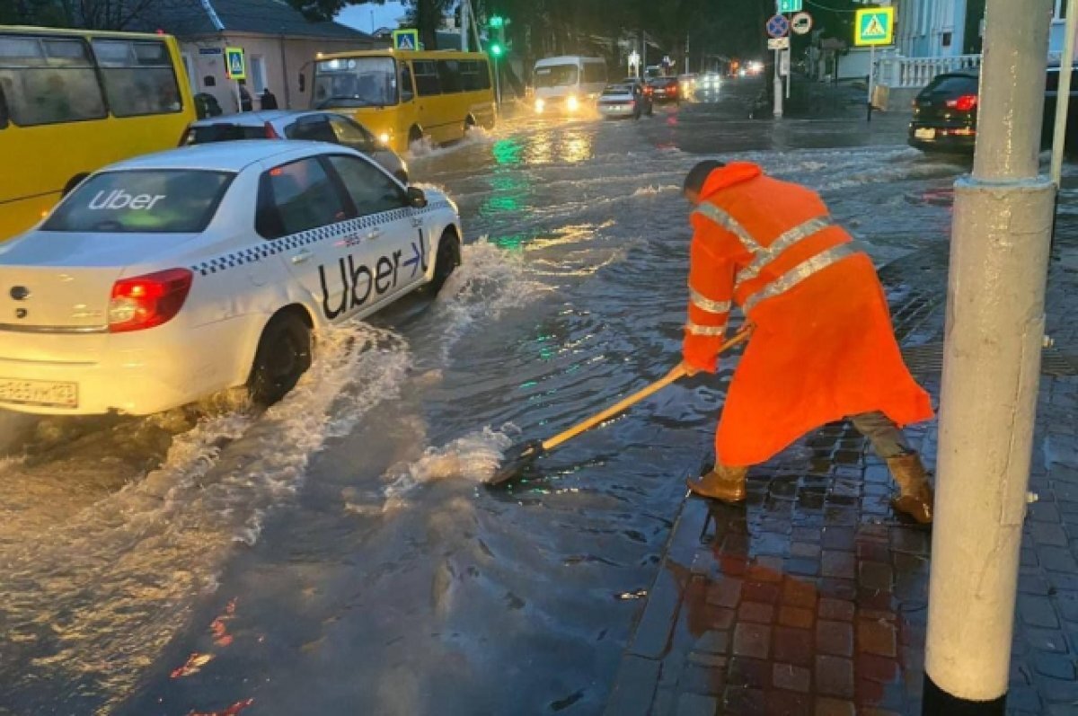    Дворники расчищают ливневки на улицах Анапы после дождя.