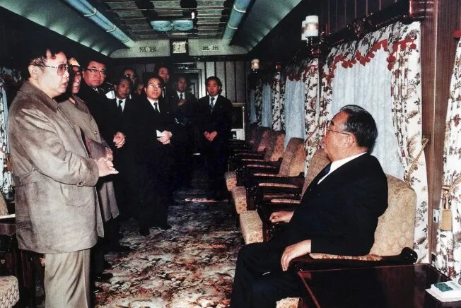 Лидер Ким Ир Сен (справа) и Ким Чен Ир беседуют в специальном поезде перед неофициальным визитом в Китай в ноябре 1989 года