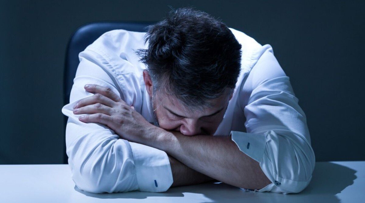 человек склонный плакать. молодой человек молится. печальный парень. опущенная голова. сильно плачет.