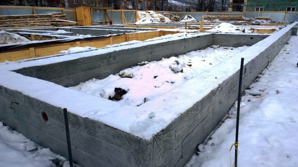 Дом с фундаментом. Фундамент зима. Консервация ленточного фундамента. Укрытие фундамента. Остров бревенник тайвань архангельск.