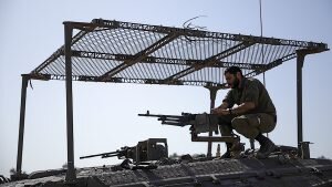    epa10990647 An Israeli soldier mans a machine gun on top of an armored vehicle at the border with the Gaza Strip, southern Israel, 23 November 2023. More than 12,700 Palestinians and at least 1,200 Israelis have been killed, according to the Israel Defense Forces (IDF) and the Palestinian health authority, since Hamas militants launched an attack against Israel from the Gaza Strip on 07 October, and the Israeli operations in Gaza and the West Bank which followed it. As part of Israel's 'ground operation' in the Gaza Strip, aerial strikes were carried out on over 300 Hamas targets over the last day, the IDF announced on 23 November. EPA/CHRISTOPHE PETIT TESSON Даниил Кугушев