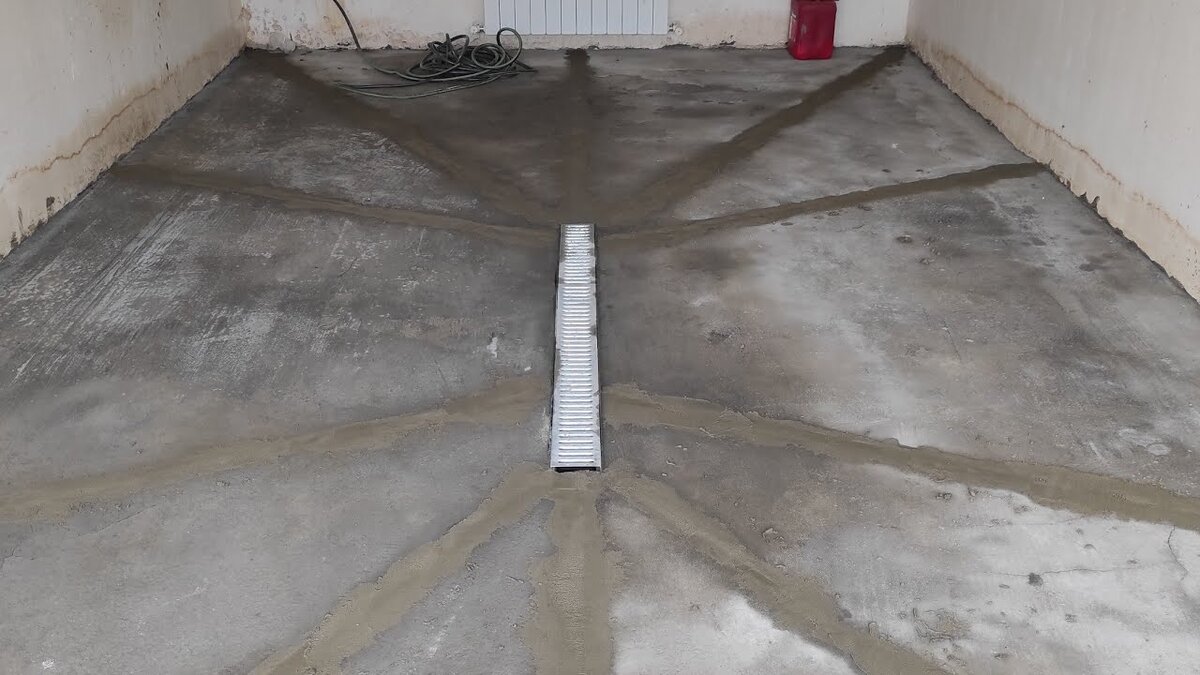 Слив по центру гаража. Не самый удобный вариант. Что будет под машиной не видно.