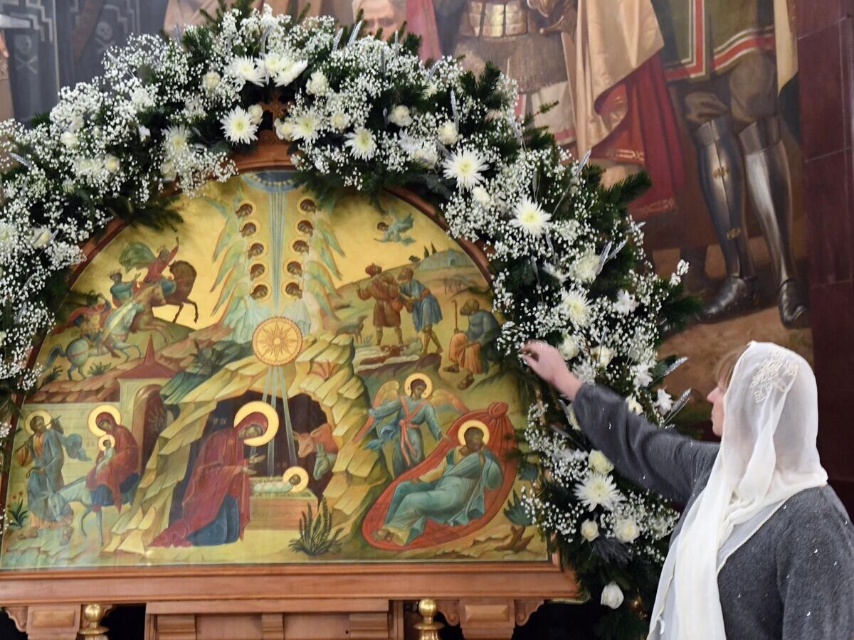    Верующая у иконы "Рождество Христово" в храме Христа Спасителя в Москве перед началом Рождественского богослужения© РИА Новости / Сергей Пятаков
