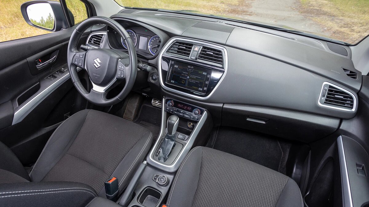 Салон SX4 кажется старым, простым и по большей части «пластмассовым», но на удивление уютным. Претензий к эргономике у водителя не накопится — и это плюс. А сама отделка не скрипит и совсем не пахнет