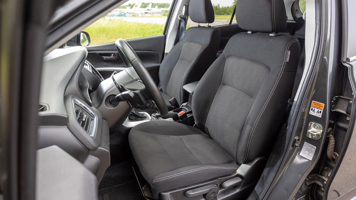 Обитые тканью кресла настраиваются только вручную, а сидеть в них удобно — спасибо удачному профилю