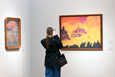    Посетительница фотографирует картину "Армагеддон", представленную на выставке "Николай Рерих" в Новой Третьяковке на Крымском валу в Москве. ©Сергей Пятаков РИА Новости