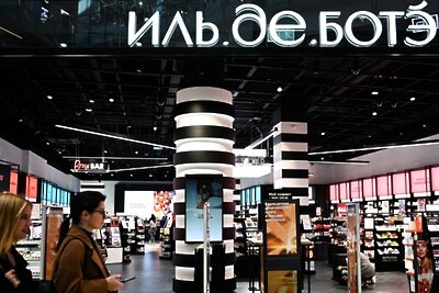    Девушки проходят мимо магазина "Иль де Ботэ" в Москве ©Рамиль Ситдиков РИА Новости