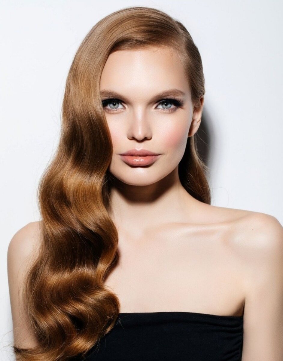 Голливудская волна Следующая модная и популярная прическа в нашем списке имеет название «Голливудская волна». Этот вариант поможет сделать любой наряд (даже самый скромный) более гламурным и нарядным. Поэтому если в ваших планах надеть лаконичное и строгое платье на Новый год, то эта прическа станет вашим лучшим выбором. Совет: не уводите локоны слишком сильно на лицо — это доставит вам дискомфорт во время праздничного веселья. Лучше сделайте их более объемными по бокам.
